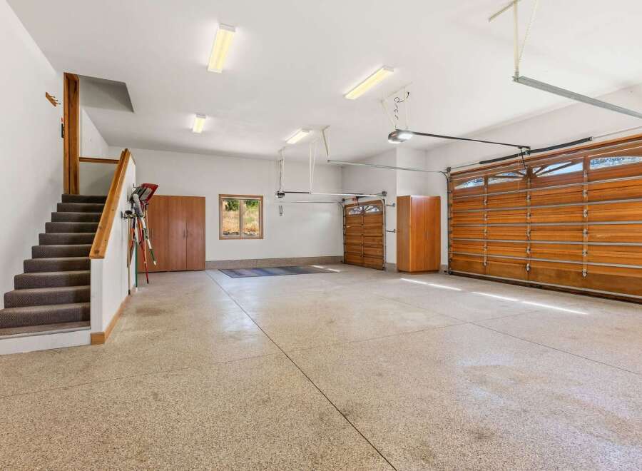 This spacious garage offers ample parking and storage with its large main bay and additional single-car garage.