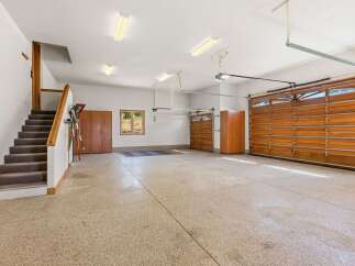 This spacious garage offers ample parking and storage with its large main bay and additional single-car garage.