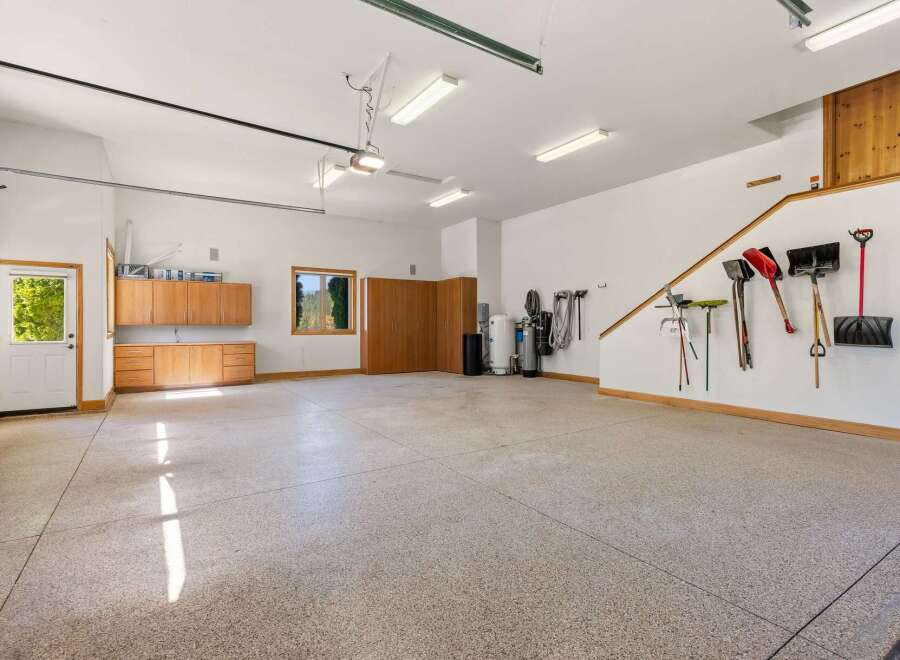 This spacious garage offers ample storage with built-in wooden cabinets and shelving units.