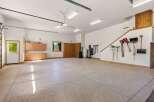 This spacious garage offers ample storage with built-in wooden cabinets and shelving units.