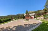 Experience luxury mountain living with this stunning property featuring a spacious paver driveway leading to a charming home with a three-car garage.