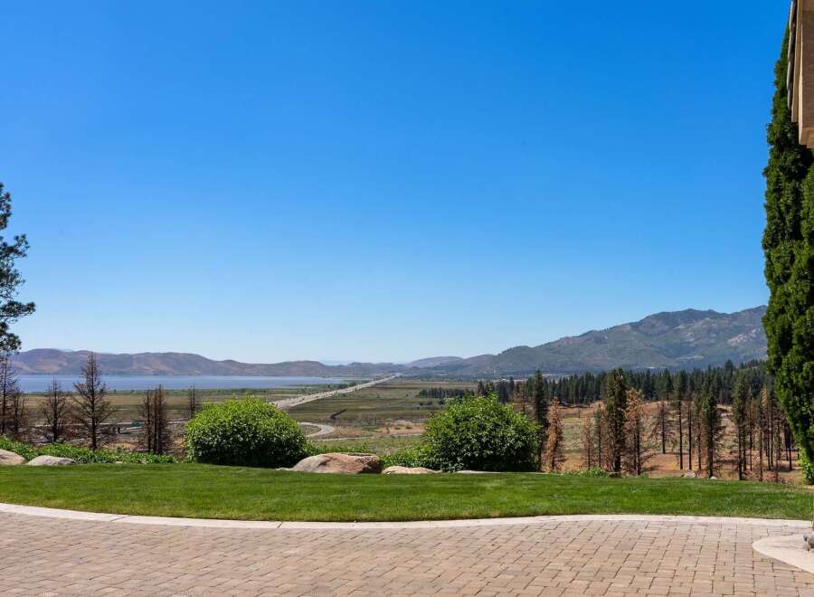 Experience breathtaking panoramic views of a serene lake and majestic mountains from this stunning property.