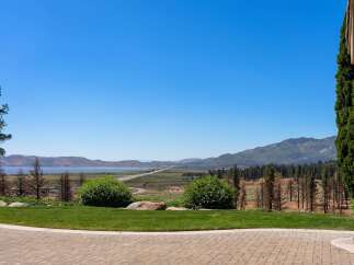 Experience breathtaking panoramic views of a serene lake and majestic mountains from this stunning property.