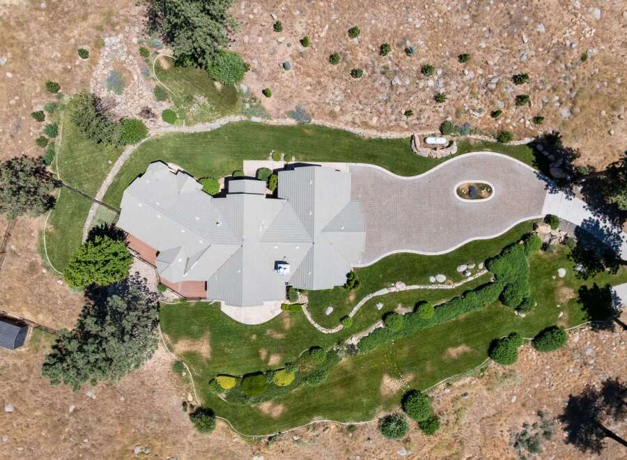 Discover this stunning aerial view of a luxurious home nestled in a picturesque landscape.