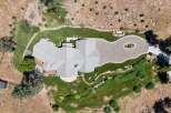Discover this stunning aerial view of a luxurious home nestled in a picturesque landscape.