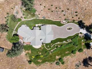 Discover this stunning aerial view of a luxurious home nestled in a picturesque landscape.