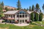 This stunning home boasts a grand facade with a large, multi-paneled window offering breathtaking views.