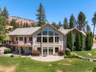 This stunning home boasts a grand facade with a large, multi-paneled window offering breathtaking views.