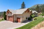 Experience luxury mountain living in this stunning property featuring a spacious three-car garage with a paver driveway and charming stone accents.