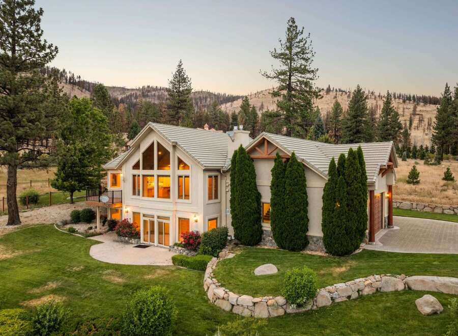 Experience luxury living in this stunning mountain home, featuring expansive windows that flood the interior with natural light and offer breathtaking views of the surrounding landscape.