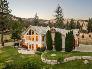 Experience luxury living in this stunning mountain home, featuring expansive windows that flood the interior with natural light and offer breathtaking views of the surrounding landscape.