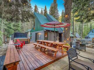 Experience the ultimate mountain getaway with this stunning property featuring a spacious wooden deck, perfect for outdoor entertaining.