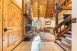 Experience rustic charm in this inviting living space, featuring a grand stone fireplace and soaring vaulted wood ceilings.