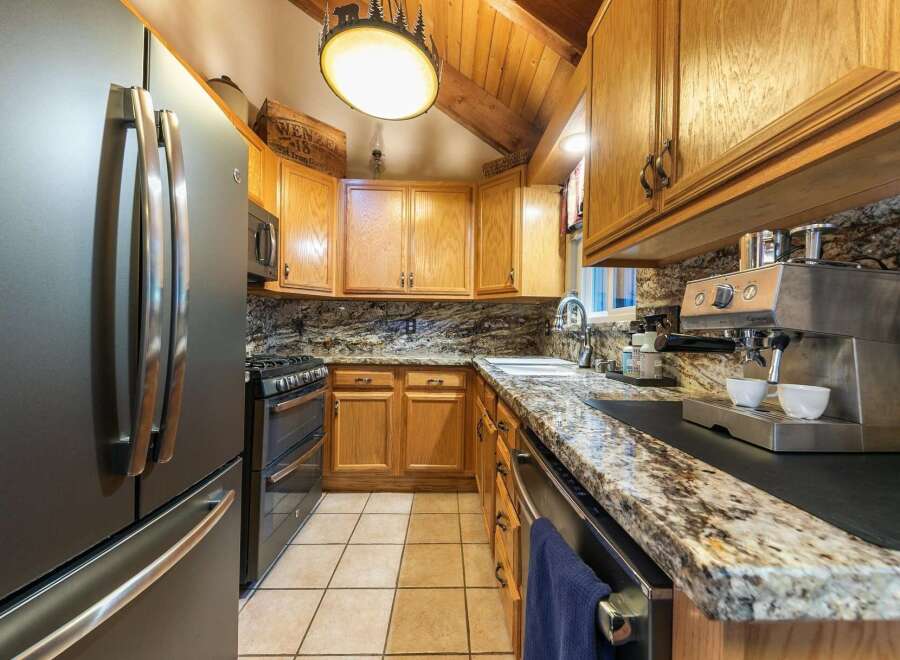 Experience rustic charm in this cozy kitchen, featuring warm oak cabinetry and elegant granite countertops.