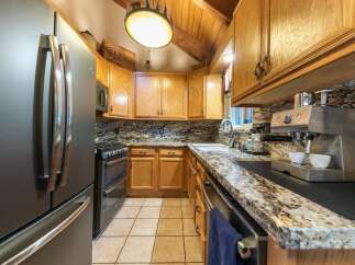 Experience rustic charm in this cozy kitchen, featuring warm oak cabinetry and elegant granite countertops.