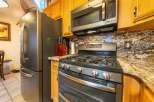This kitchen boasts a sleek stainless steel refrigerator and a modern gas range, perfect for any home chef.