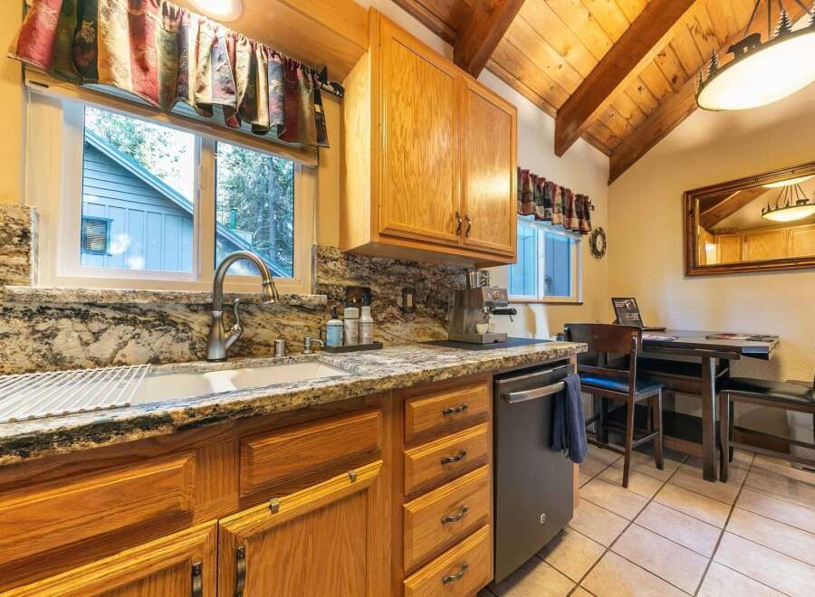 This charming kitchen boasts beautiful granite countertops and warm oak cabinetry, creating a cozy and inviting atmosphere.