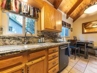 This charming kitchen boasts beautiful granite countertops and warm oak cabinetry, creating a cozy and inviting atmosphere.