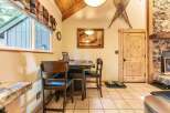 Enjoy cozy meals in this charming dining area, featuring a rustic wooden table and chairs perfect for intimate gatherings.