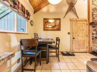 Enjoy cozy meals in this charming dining area, featuring a rustic wooden table and chairs perfect for intimate gatherings.