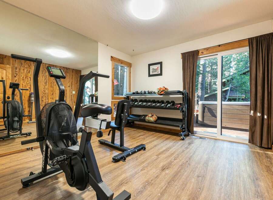 Elevate your fitness routine in this dedicated home gym, featuring a Rogue Echo Bike and a comprehensive dumbbell rack.