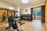 Elevate your fitness routine in this dedicated home gym, featuring a Rogue Echo Bike and a comprehensive dumbbell rack.