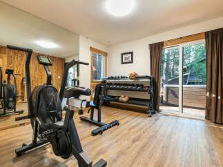 Elevate your fitness routine in this dedicated home gym, featuring a Rogue Echo Bike and a comprehensive dumbbell rack.