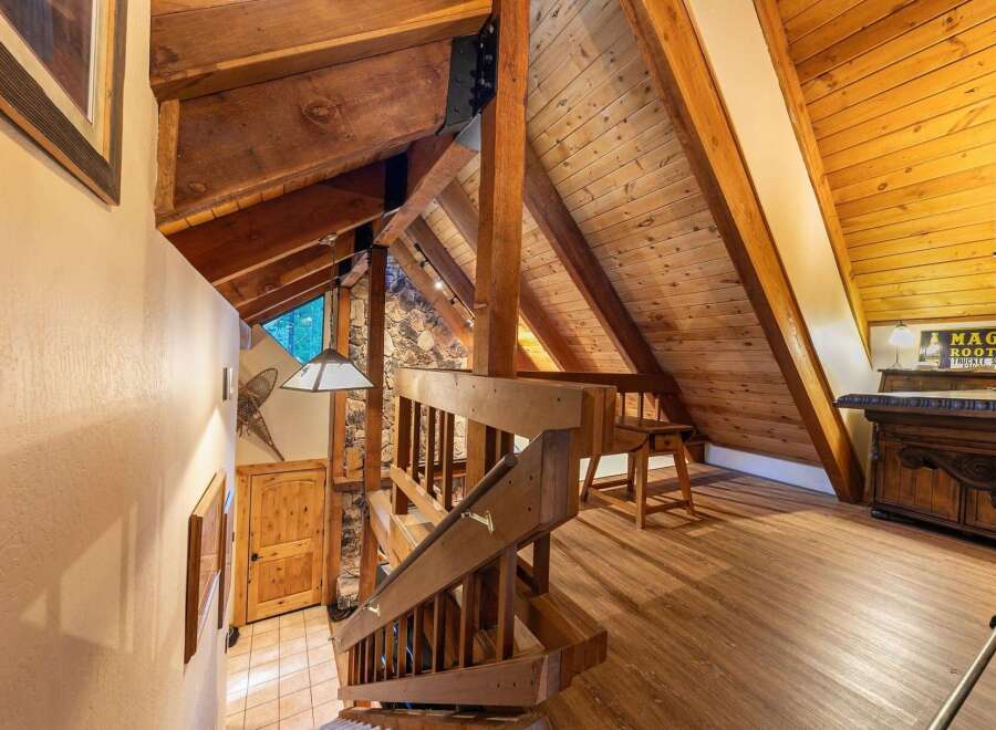 Experience rustic charm in this mountain home featuring exposed wooden beams and a stone accent wall.