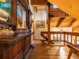 Step into a rustic lodge-style home featuring a stunning wooden bar and intricate detailing.