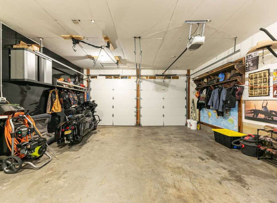 This spacious garage offers ample storage and parking for multiple vehicles, including two motorcycles.