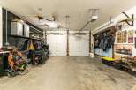 This spacious garage offers ample storage and parking for multiple vehicles, including two motorcycles.
