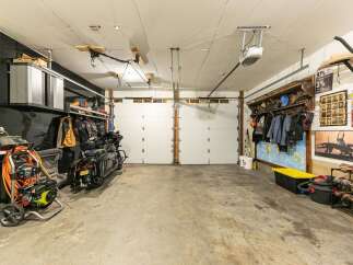 This spacious garage offers ample storage and parking for multiple vehicles, including two motorcycles.