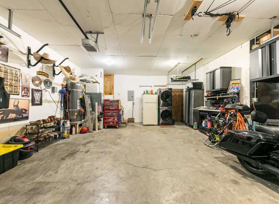 This spacious garage offers ample storage solutions, including shelving units and a red rolling tool chest, perfect for organizing your tools and equipment.
