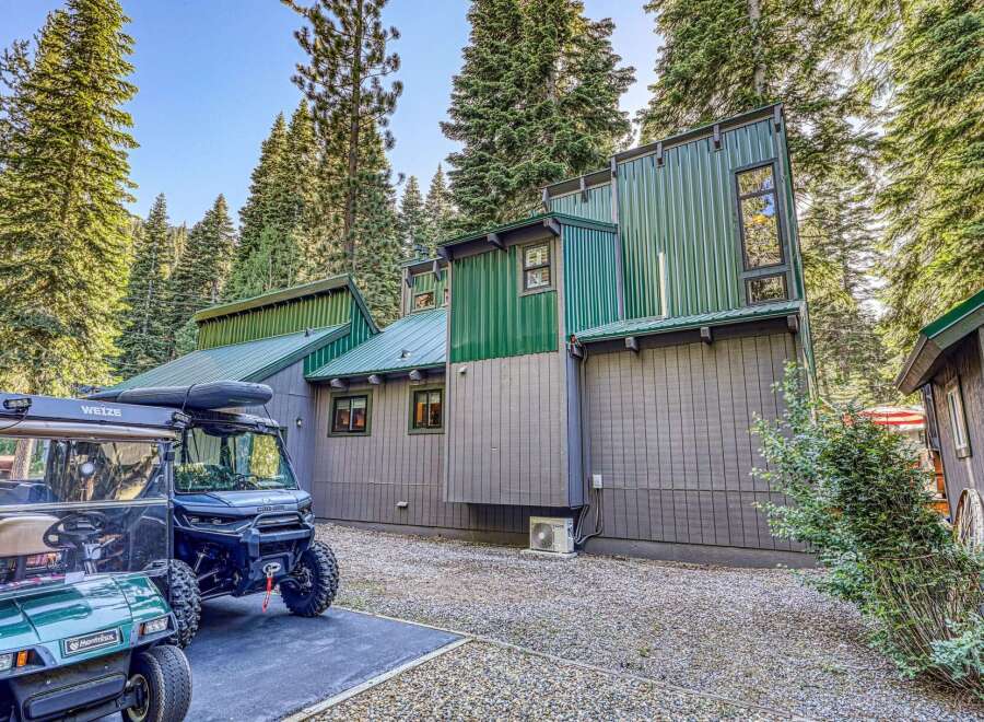 Discover this unique mountain retreat featuring a modern architectural design with striking green metal siding and a complementary gray wood exterior.