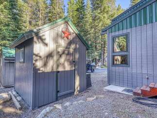 Discover this charming property featuring a rustic shed with a decorative star, perfect for storage or a creative space.