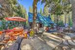 Escape to this charming cabin nestled in the woods, featuring a spacious wooden deck with a picnic table and umbrella, perfect for outdoor dining.