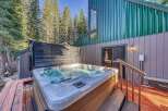 Indulge in ultimate relaxation with this luxurious hot tub, perfectly situated on a private wooden deck surrounded by towering pine trees.