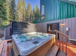 Indulge in ultimate relaxation with this luxurious hot tub, perfectly situated on a private wooden deck surrounded by towering pine trees.