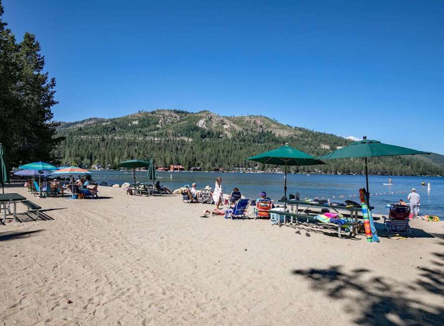 Enjoy a perfect summer day at this beautiful lakeside property, featuring a sandy beach and crystal-clear waters.
