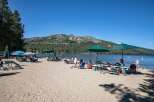 Enjoy a perfect summer day at this beautiful lakeside property, featuring a sandy beach and crystal-clear waters.