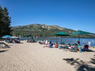 Enjoy a perfect summer day at this beautiful lakeside property, featuring a sandy beach and crystal-clear waters.