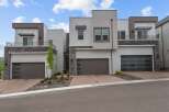Discover modern luxury in this stunning townhome featuring a sleek stucco exterior and striking stone accents.