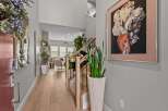 Step into this inviting entryway featuring a striking Buddha wall art and a modern staircase with elegant railings.