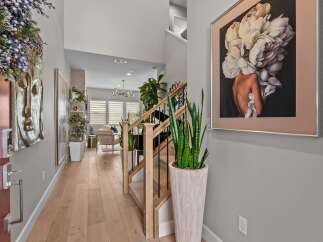 Step into this inviting entryway featuring a striking Buddha wall art and a modern staircase with elegant railings.