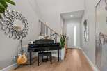 This elegant entryway features a stunning black grand piano, perfect for music lovers.