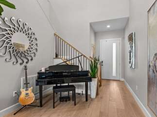 This elegant entryway features a stunning black grand piano, perfect for music lovers.
