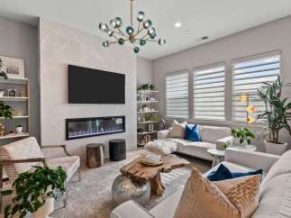 Experience modern luxury in this stunning living room, featuring a sleek fireplace and a large wall-mounted TV as the focal point.