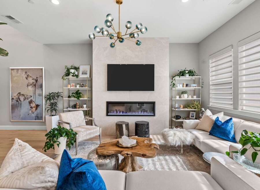 Experience modern living in this stunning living room, featuring a sleek fireplace and a large flat-screen TV as the focal point.