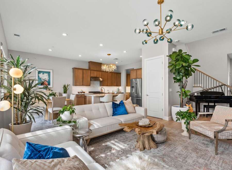 Experience modern living in this spacious open-concept home, featuring a gourmet kitchen with rich wood cabinetry and a stunning crystal chandelier.