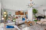 Experience modern living in this spacious open-concept home, featuring a gourmet kitchen with rich wood cabinetry and a stunning crystal chandelier.